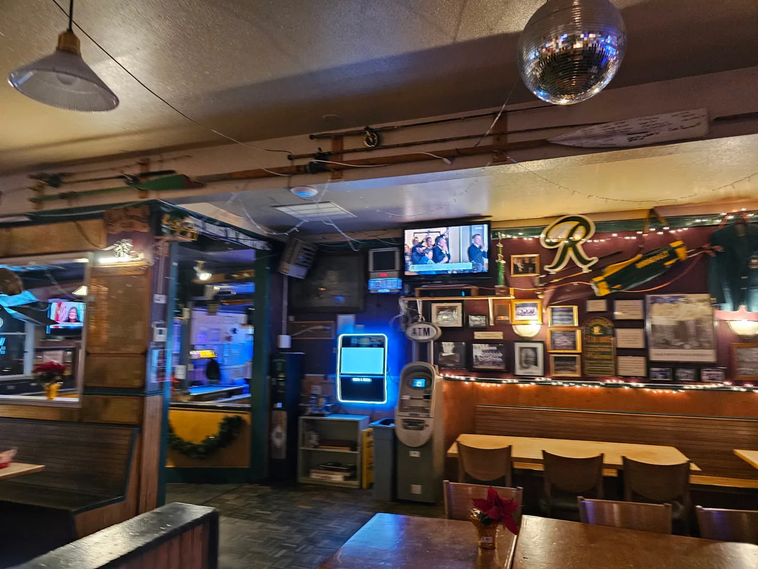 The Duchess back room with a mirror ball, wooden booths, framed photographs and televisions