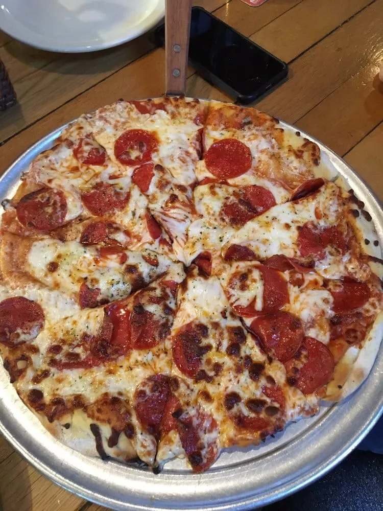 A whole pepperoni pizza on a metal tray at the Duchess Tavern